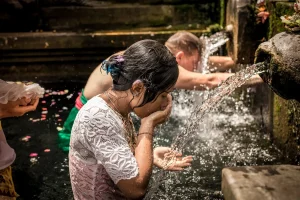BALI, INDONESIA - DECEMBER 5, 2017: Holy spring water. People praying in the Tirta Empul temple. Bali, Indonesia.